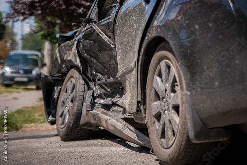 Fotografie Side collision damage on black car with crushed door and scratched body, afterma