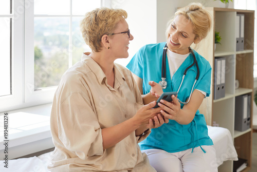 Wallpaper Mural Nurse showing health results to happy senior patient on smartphone during clinic visit, explaining how to use health mobile app easy. Smiling woman using mobile phone with help of doctor Torontodigital.ca