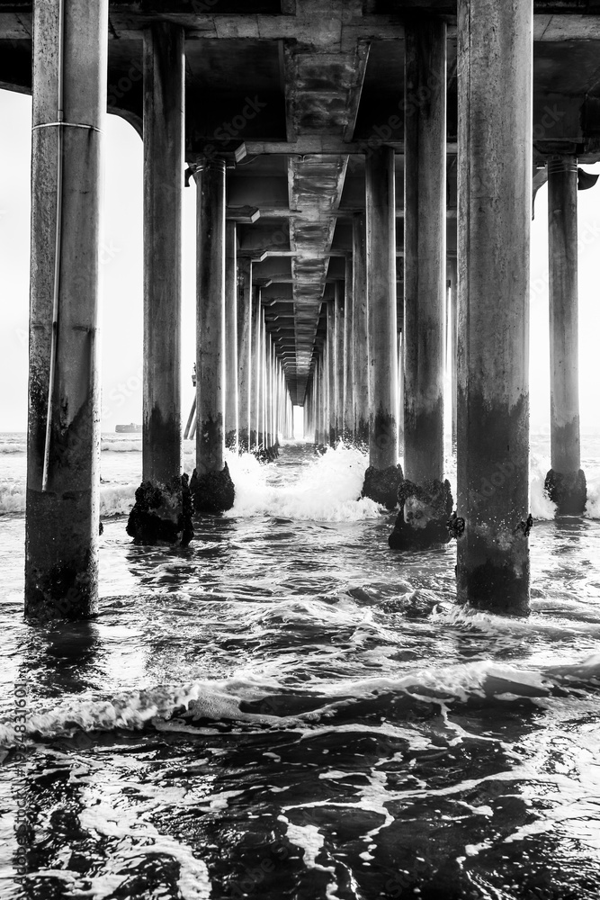 Fototapeta premium Black and white perspective under the Huntington Beach Pier in Huntington Beach, California