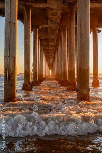 Golden hour under the iconic pier structure in Huntington Beach, California