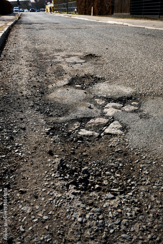 Damaged Asphalt Road with Potholes and Deteriorating Surface