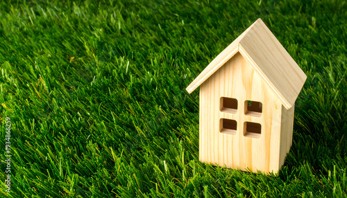 Wooden House Model on Green Grass Lawn