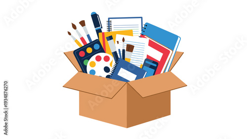 Open cardboard box filled with various school supplies like notebooks, paint palettes, brushes, and pens for a new semester or art class.