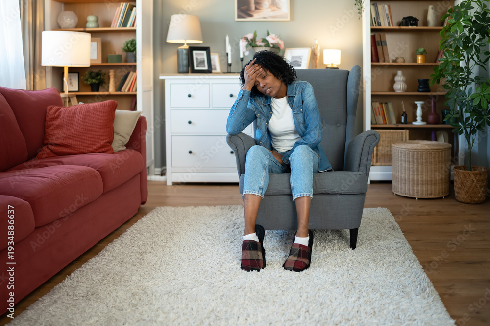 Obraz premium Stressed woman experiencing headache in home living room