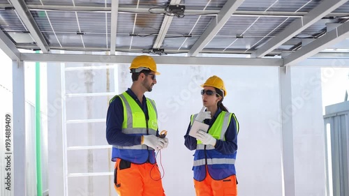 Engineers inspecting solar panel maintenance and electrical system check on rooftop, Maintenance engineers team in safety uniform discussing solar farm installation and efficiency