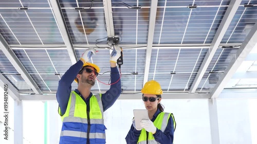 Engineers inspecting solar panel maintenance and electrical system check on rooftop, Professional technicians team working with digital tablet at solar power station for renewable energy