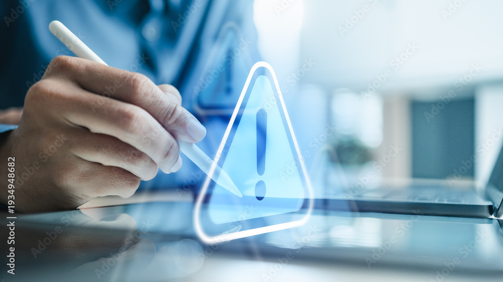 Obraz premium Business professional using tablet with digital warning sign icon, representing cybersecurity threat, data protection, privacy risk and information security management concept.