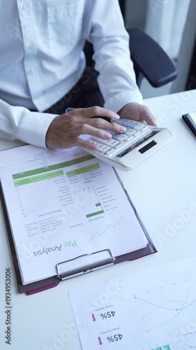 Businessman holding and press botton on calculator over documents