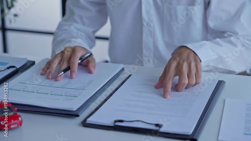 Businessman doing car insurance document with car model on table
