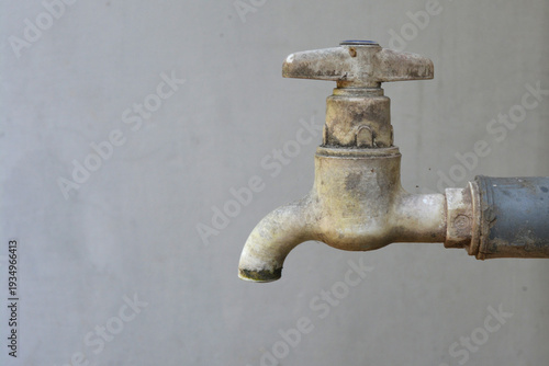 Old Weathered Plastic Water Tap on Outdoor Wall Background, Close-up of Grimy Domestic Faucet for Water Conservation, Plumbing Infrastructure, Industrial Utility Concept, and Rural Water Access 