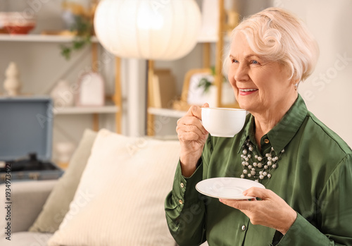 Beautiful senior woman drin...
