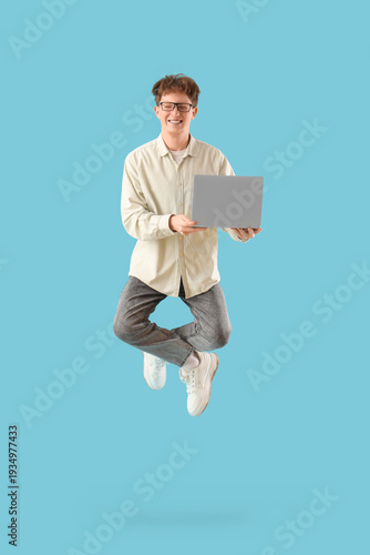 Young man with laptop jumpi...