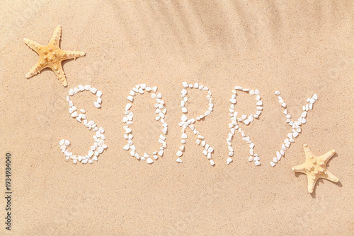 Cuadro en lienzo Word SORRY made of pebbles with starfishes on sand