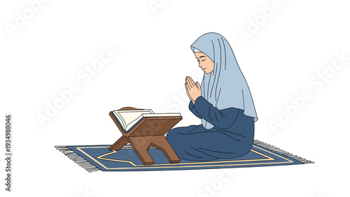 Young Muslim girl wearing a blue hijab is sitting on a prayer rug and praying with an open book on a wooden stand.