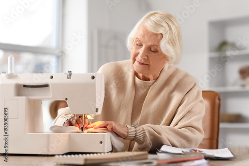 Senior female tailor sewing...