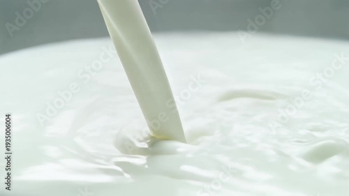 Close up of creamy milk being poured through a straw in a white, refreshing scene.