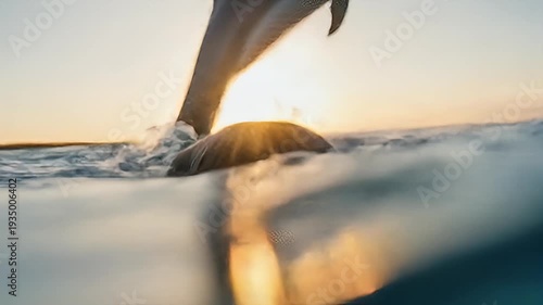 Man with wet hair looks into the camera from underwater in turquoise, wavy water