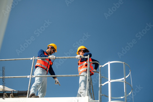 Engineering team discussing installation points on an industrial structure platform