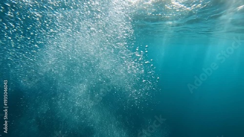 Underwater bubbles rising towards the surface in clear blue ocean water