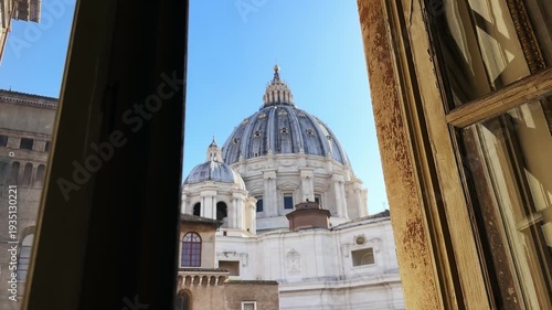 Vatican scene seen through open blinds window with view of Saint Peter basilica church in Vatican City on sunny summer day, Rome, Italy