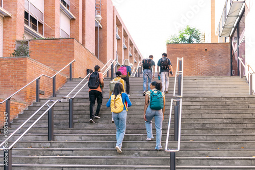 Obraz na plátně Group of diverse students with backpacks walking up outdoor stairs at a universi