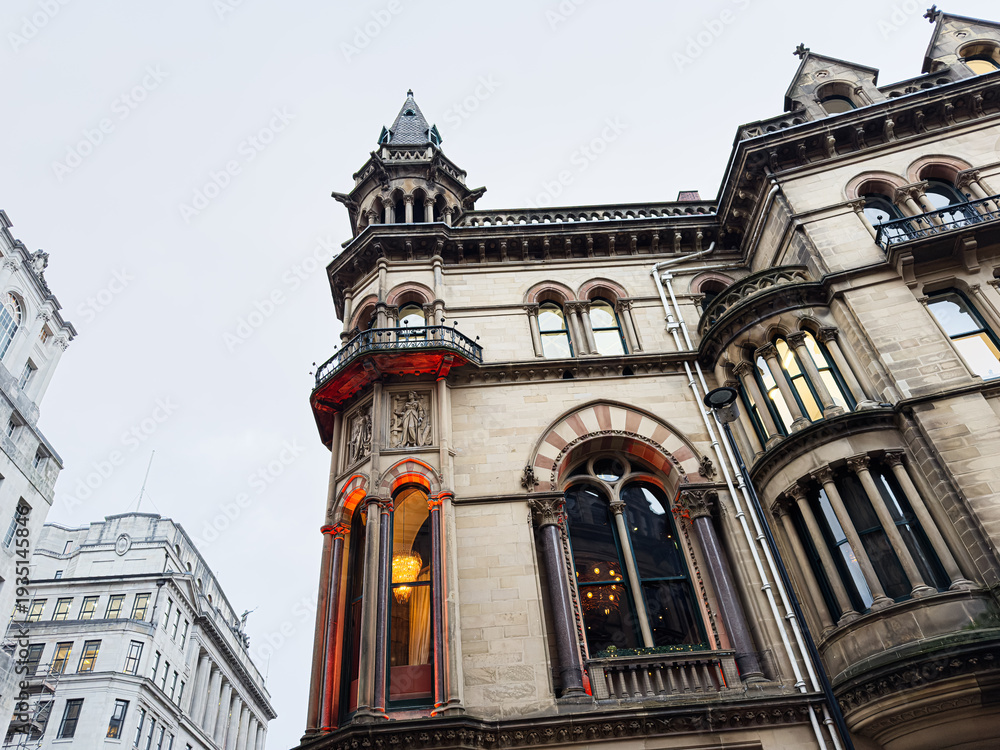Fototapeta premium Historic Manchester building with ornate towers and tall windows on a city street