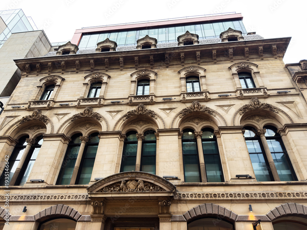 Fototapeta premium Historic stone building in Manchester, UK with ornate arches and grand arched windows