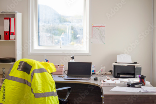 Photos Workstation set up with a laptop and documents in an office during daylight hour