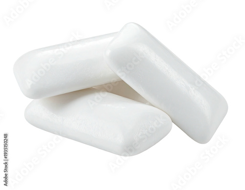 A close-up, high-angle view of three white, rectangular pieces of gum