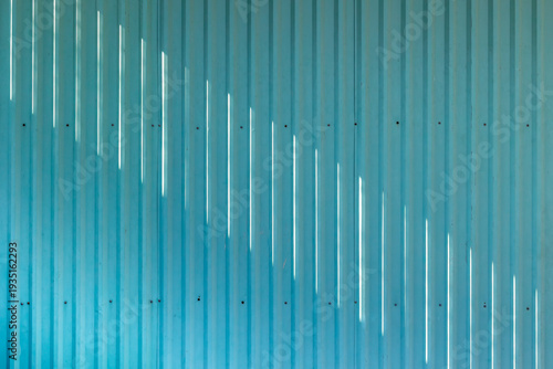 Corrugated metal panels with slotted light on teal wall