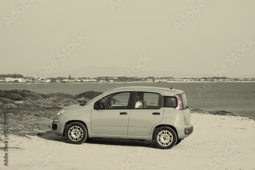 Foto Small car parked near Torre di Sa' Mora tower, Capo Mannu promontory, Sardinia,