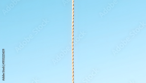 Single rope hanging in clear sky, symbolizing freedom