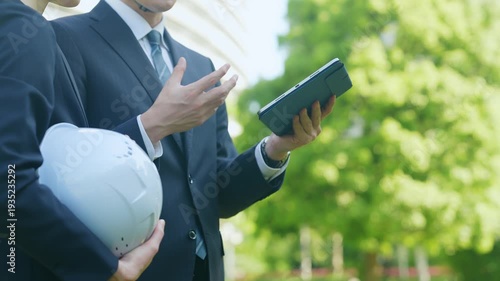 タブレットを見ながら相談する男女作業員