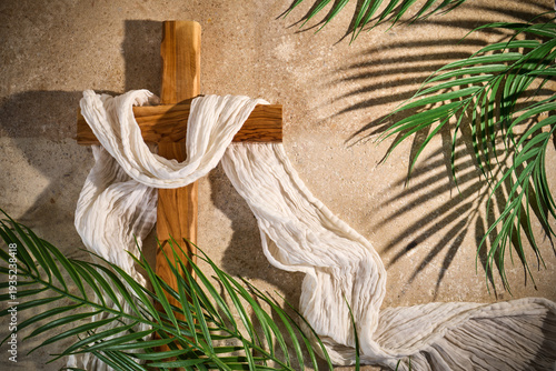 Wooden cross draped white fabric with palm leaves