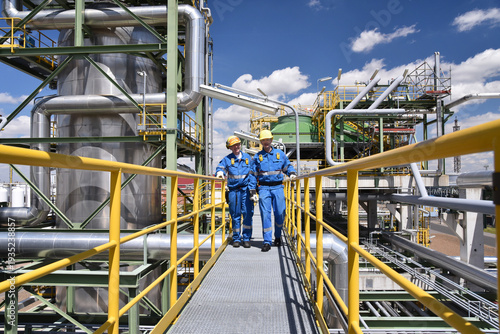 group of workers professional equipment in a petroleum refinery - modern buildings and industrial facilities for the production of fuel and gas