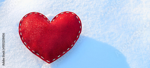 a banner of a stitched, red, sparkling heart on the snow on a frosty, sunny, winter day