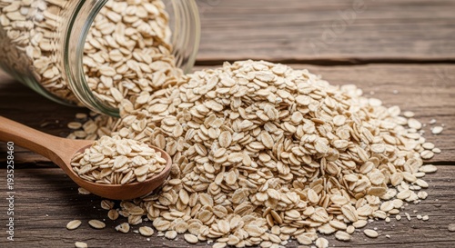 A wooden spoon filled with oats next to a glass jar on a rustic wooden table
