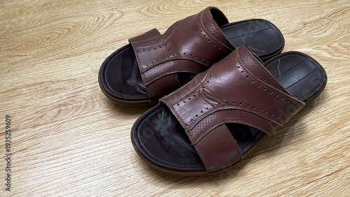 Obraz na plátne Brown leather sandals on a wooden floor with white mold on the insoles