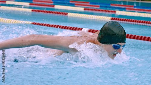 Fotografia Freestyle stroke by swimmer with short hair, black swim cap and goggles