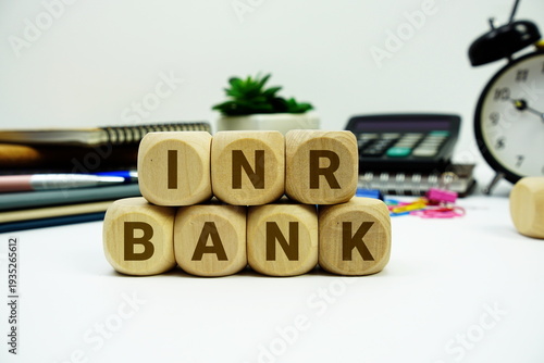 INR Bank alphabet letters with calculator and alarm clock on white background