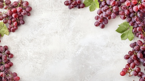 Fresh bunches of purple grapes arranged artistically on a light textured background
