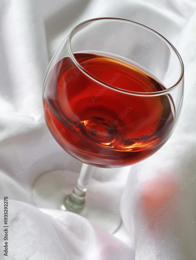Fototapeta premium Elegant glass of deep red wine resting gently on a soft white cloth, inviting a moment of indulgence Generative AI