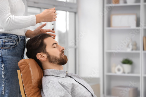 Konstfotografi Female psychologist with pendulum hypnotizing man in office