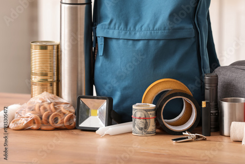Bild auf Leinwand Emergency backpack with necessities on table in kitchen, closeup
