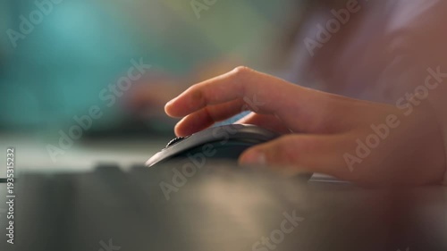 Male's hand using mouse, side view. A hand moves over a computer mouse at a desk.  The setting is an office during day time. Businessman or student using laptop at home, online learning, internet mark