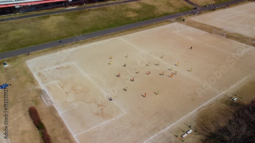 土手沿いのコートでサッカーをする少年を空撮　4K