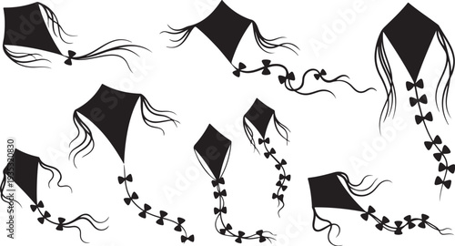 Black kites flying in the air with tails streaming