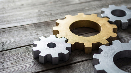 Close-up of assorted silver gears on a weathered wooden surface, illustrating mechanical components and the concept of interconnected systems.
