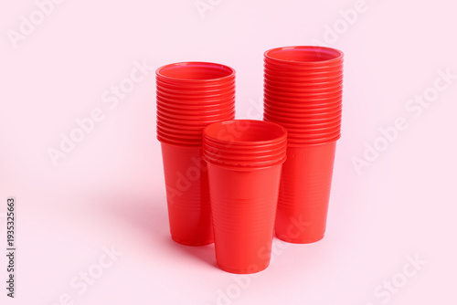 Red plastic cups on pink ba...