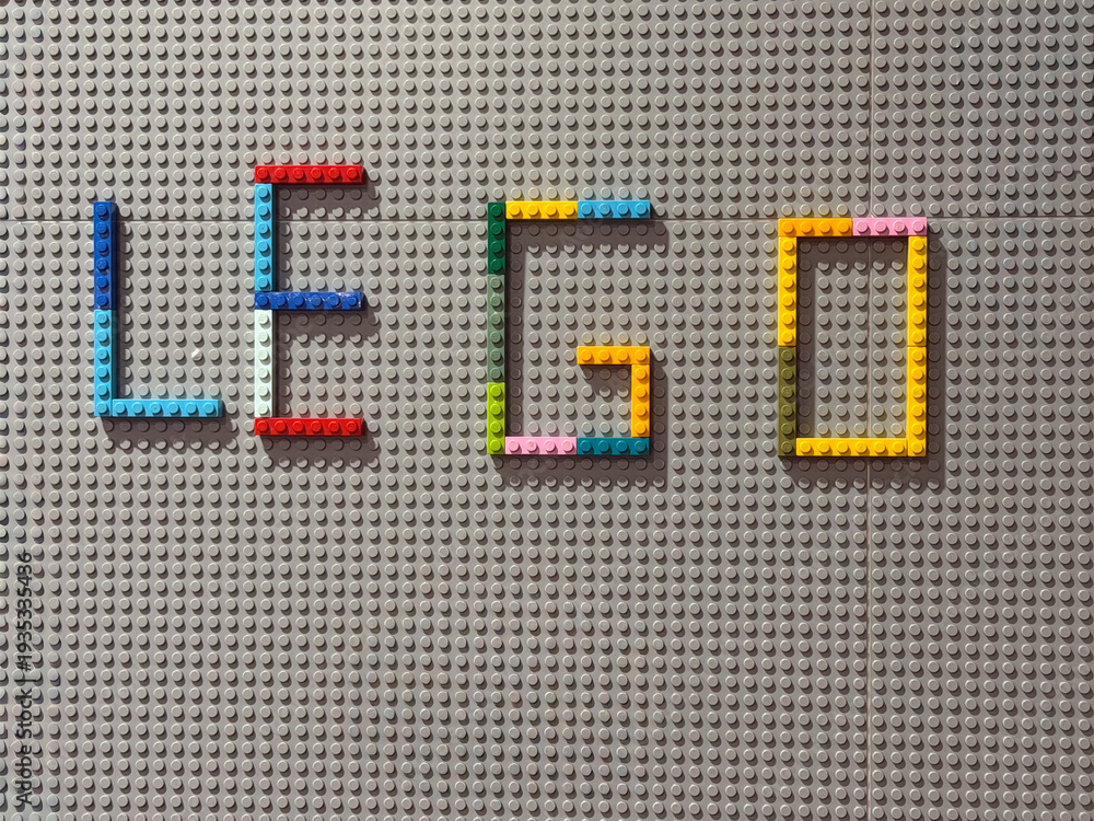 Fototapeta premium Colorful lego bricks spelling 'lego' on gray baseplate
